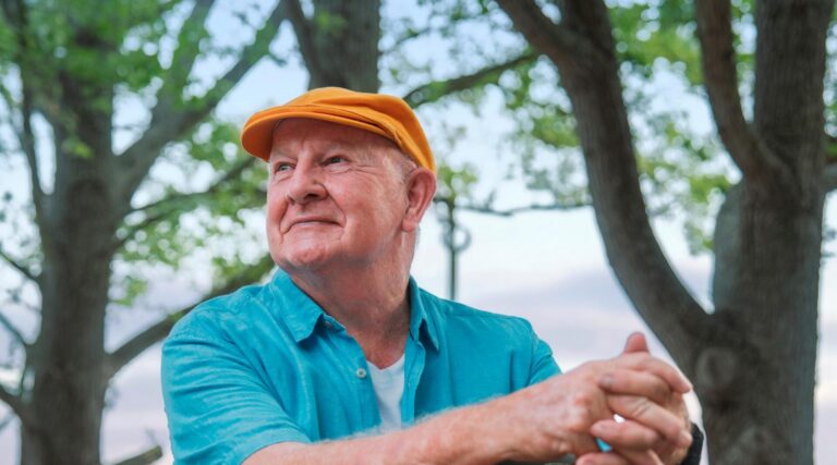 Man in blue shirt and yellow cap, sitting on a Humfree Connect mobility scooter