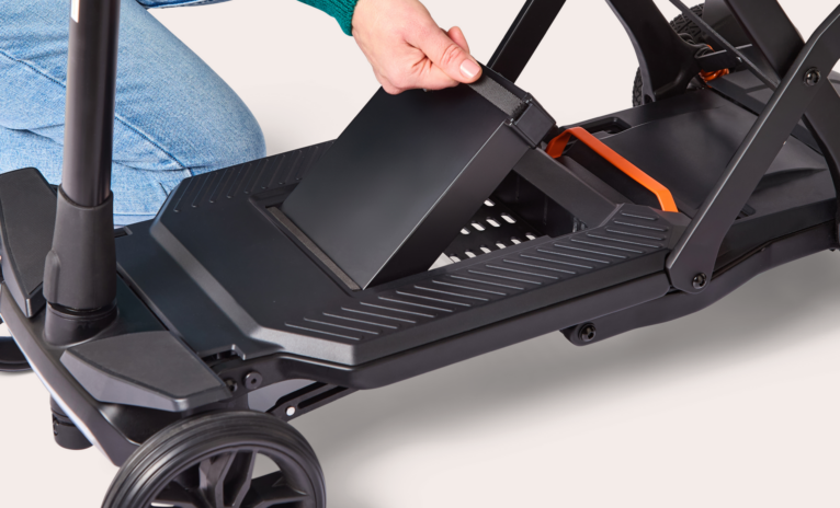 Close up of womans hand lifting battery out of charcoal Humfree carbon scooter