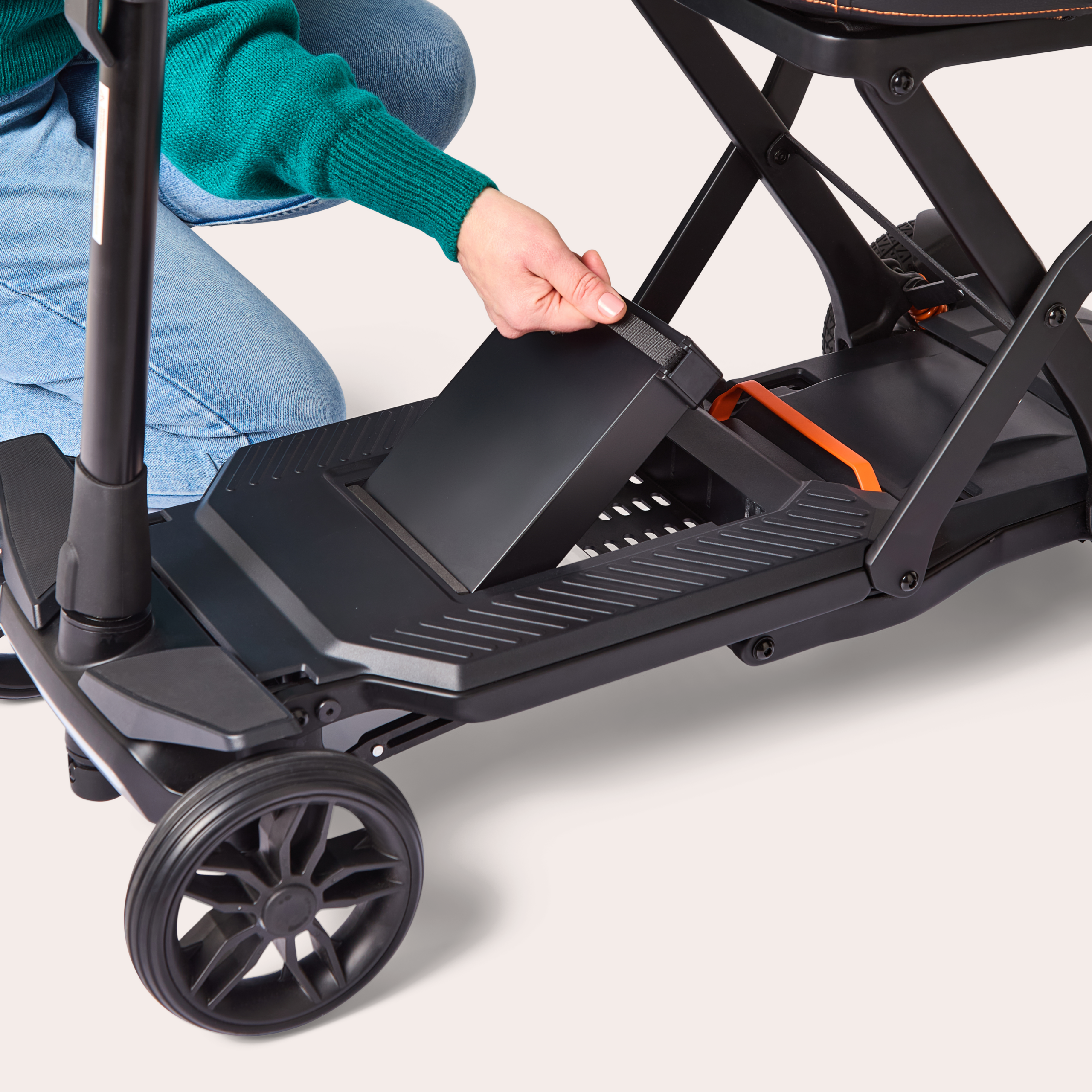 Close up of womans hand lifting battery out of charcoal Humfree carbon scooter