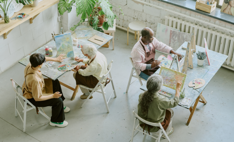 Ariel view of older people taking part in a painting workshop