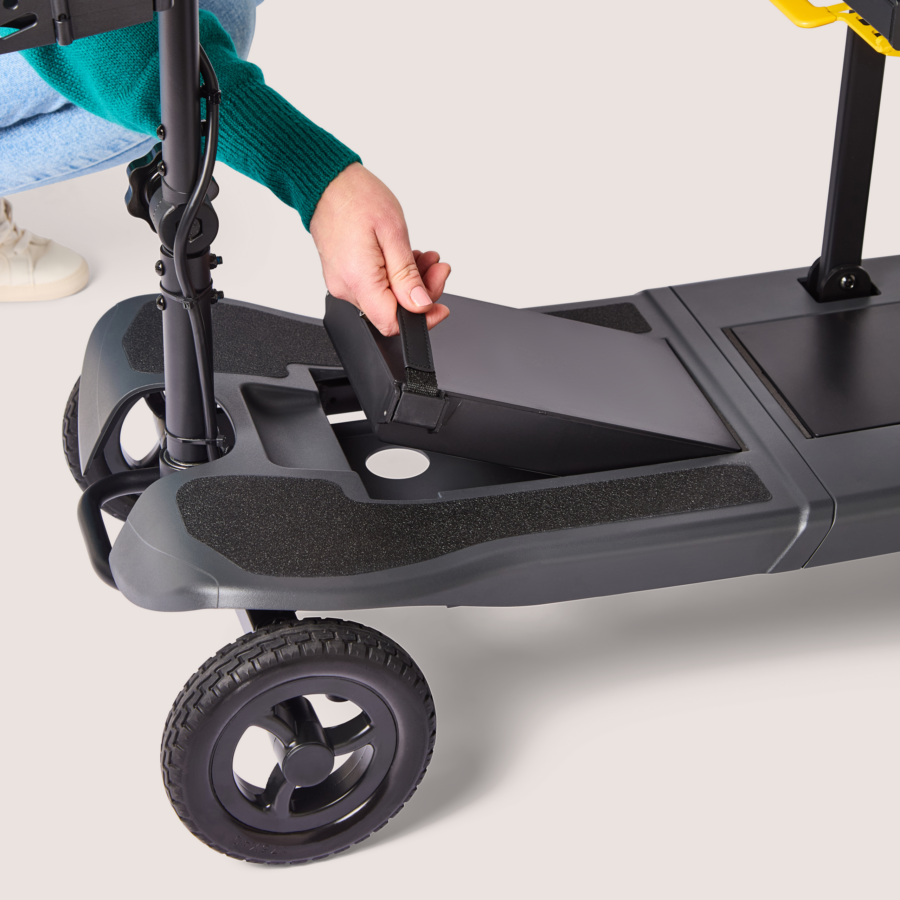 Close up of womans hand lifting battery out of charcoal Humfree lite scooter
