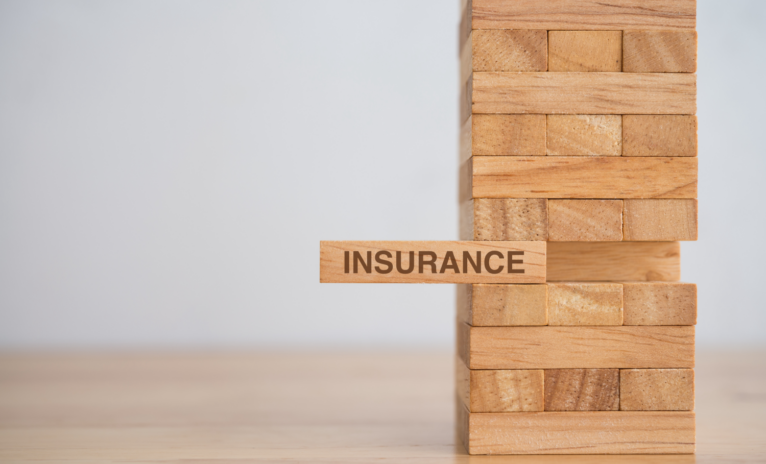 Jenga stack with one block sticking out that has insurance printed on the side